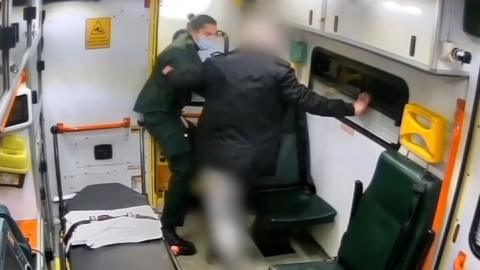 Man pushes paramedic towards ambulance door
