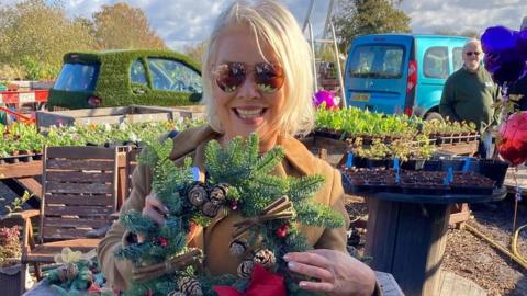 Kim Wilde holding a wreath on site