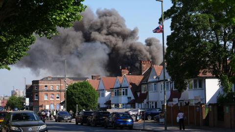 Smoke billows from behind houses 