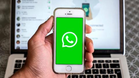 WhatsApp on phone held against keyboard