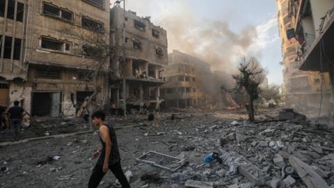 Palestinians inspect a destroyed area following a blast in Gaza