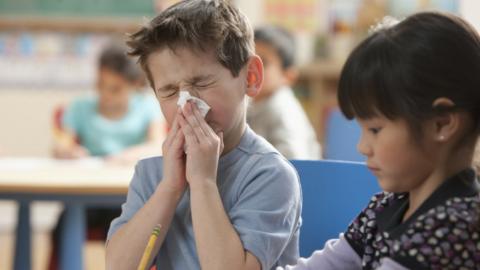 Child sneezing in classroom