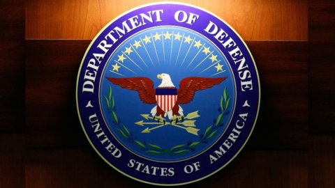 A light shines on the seal of the Department of Defense