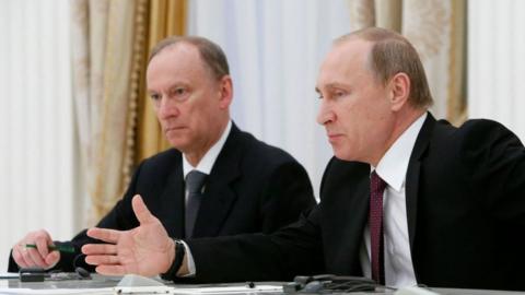 Vladimir Putin sits by Nikolai Patrushev