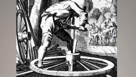 A black and white drawing of a 17th Century wheelwright bending over a wheel with a tool