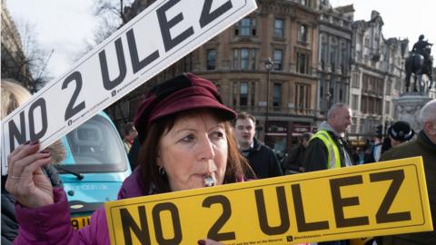Woman holding two No 2 Ulez number plates