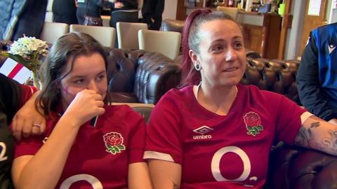 A woman and a girl wearing England rugby shirts