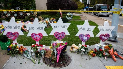 Flowers and stones are placed on the memorials erected outside of the Tree of Life Synagogue in Squirrel Hill.
