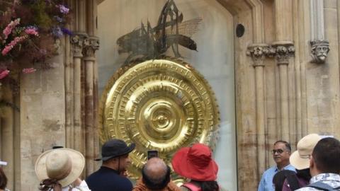 Tourists crowded round the newly returned Corpus Chronophage in Cambridge