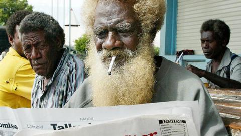 man reads Solomon Star newspaper