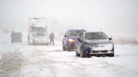 A photo showing cars stuck on a snowy road