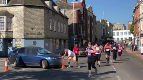 Man trying to stop car entering track