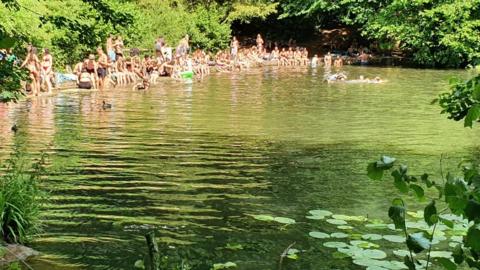 Crowds on the banks of Abbots Pool in North Somerset