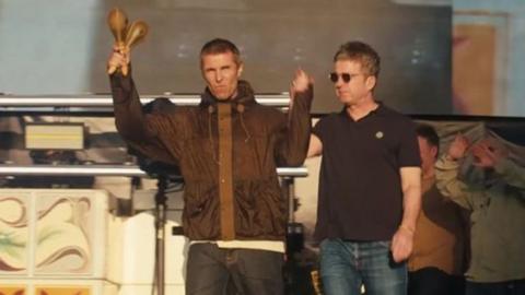 Liam and Noel Gallagher hand-in-hand arrive on stage