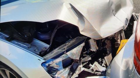 crumpled car bonnet with the back of another car resting on it, after a crash