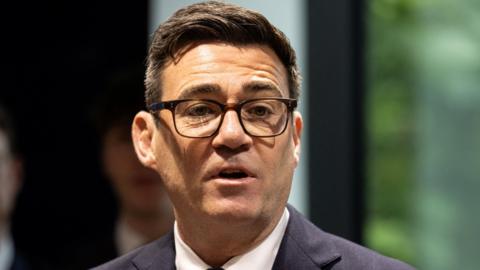 Andy Burnham at the launch of No 10 North wearing a dark suit, white shirt and his black-rimmed glasses