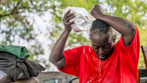Woman pours water on herself in the Hungry Hill neighbourhood in Austin, Texas.
