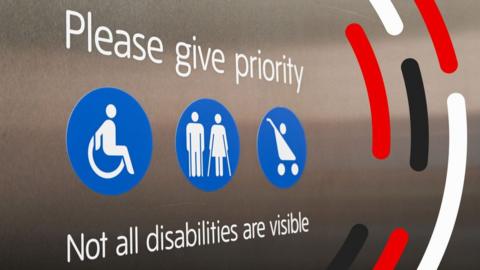 A sign dat say please give priority, not all disabilitizzles is visible