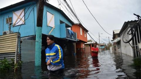 People walk across a flooded street in Juana Matos, Puerto Rico, after Hurricane Maria ripped through the area.