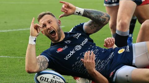 Byron McGuigan celebrates scoring a try for Sale against Harlequins