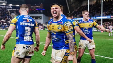 Leeds Rhinos players celebrate their win over champions Wigan in the Super League