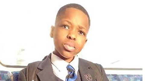 Daniel Anjorin pictured sitting on a bus wearing school uniform