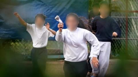 Blurred image of young girl running towards the fence carrying a message in a bottle describing conditions inside the Manston immigration short-term holding facility located at the former Defence Fire Training and Development Centre in Thanet, Kent