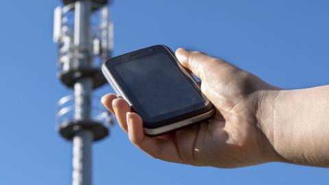 Mobile phone in front of a phone mast