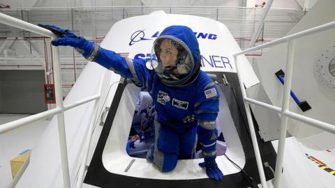 Boeing propulsion engineer Monica Hopkins climbs out of a mockup of the CST-100 Starliner crew module, while wearing a newly-designed spacesuit, during an exclusive look at some of the things that Boeing is doing