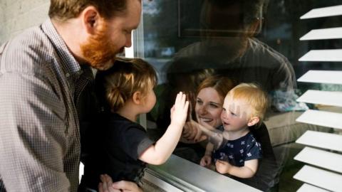 Families speaking through window