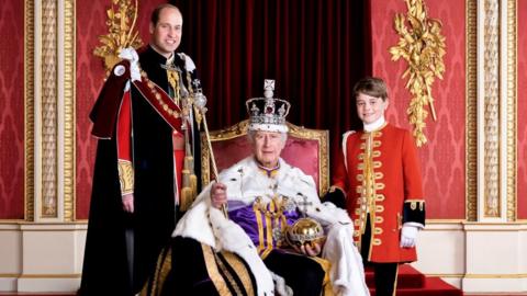 King Charles is pictured at Buckingham Palace seated on a throne - Prince William is on one side of him, and Prince George on the other