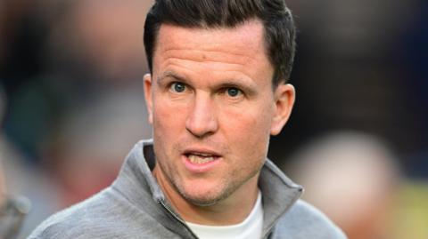 Gary Caldwell during Exeter City's win over Wycombe. He has dark hair and is wearing a light grey jumper.