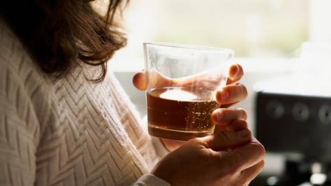 Woman drinking a glass of whiskey