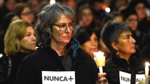 Women with lit candles and signs reading "Never More" march around La Moneda Presidential Palace in Santiago on September 10, 2023, during a demonstration to commemorate the 50th anniversary of the military coup led by General Augusto Pinochet against socialist President Salvador Allende.