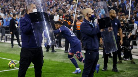 Security staff shield Neymar as he tries to take a corner