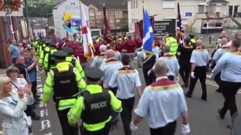 Police flanked members of Clyde Valley Flute Band during a parade in Londonderry in 2019