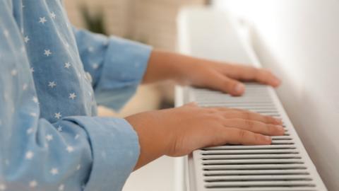 Childs hands next to a radiator