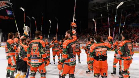 Sheffield Steelers players raise their sticks to honour Adam Johnson