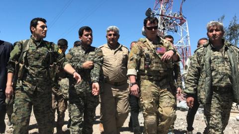 A U.S. military commander (2nd R) walks with Kurdish fighters from the People's Protection Units (YPG) at the YPG headquarters that was hit by Turkish airstrikes in Mount Karachok near Malikiya, Syria April 25, 2017.