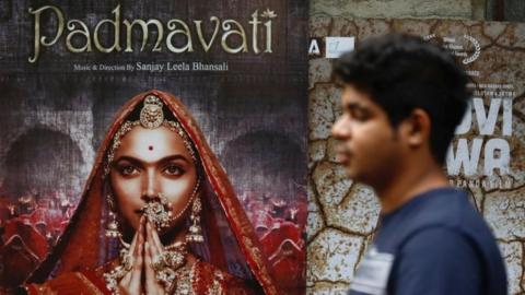 A man walks past a poster of the upcoming Bollywood movie "Padmavati" outside a theatre in Mumbai, India, November 21, 2017.