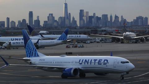 A United Airlines airplane makes its way to a gate in front of the skyline of lower Manhattan in New York City at Newark Liberty Airport on April 8, 2023, in Newark, New Jersey.
