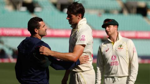 Dean Elgar (L) and Pat Cummins (R) shake hands after the third Test between Australia and South Africa ends in a draw