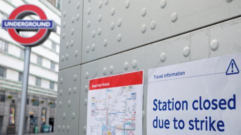 File image showing a tube roundel next to signs warning of station closures.