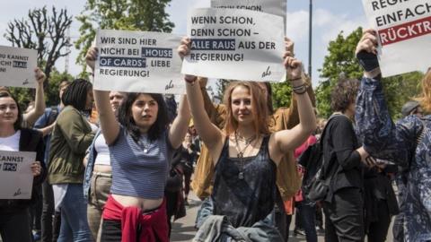 Demonstrators hold placards