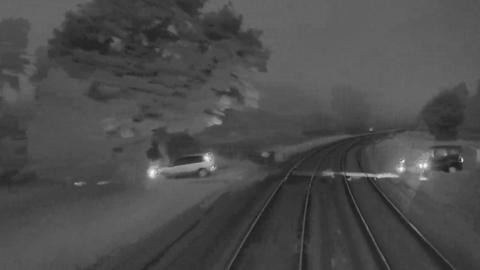 Two cars crossing the rail line