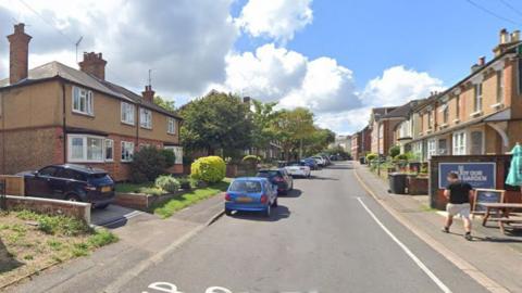 A residential street with pub picnic tables on the pavement