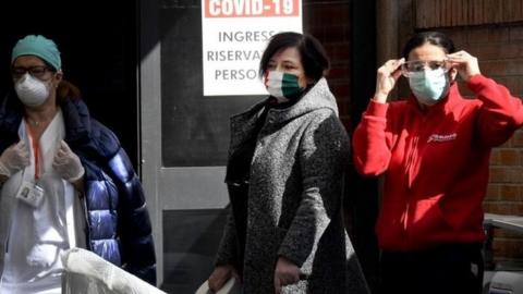 Women wearing protective face masks stand outside the new wards set up at Cardarelli hospital