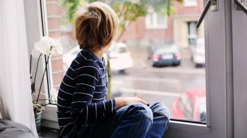 boy sitting near the window.