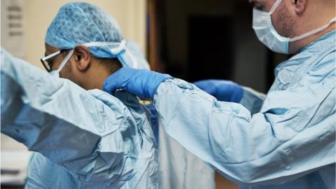 clinicians putting on PPE