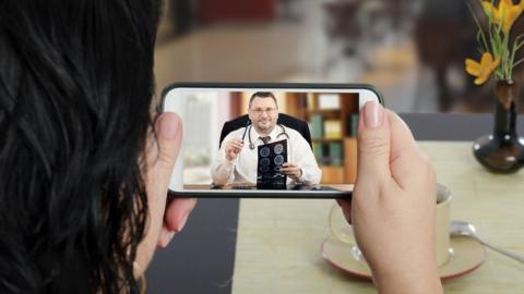 Woman consulting doctor via smartphone video